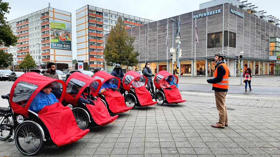 Fünf besetzte Rikschas stehen aufgereiht in der Magdeburger Innenstadt